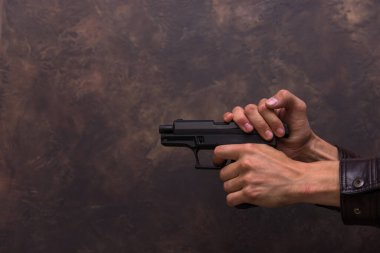 Kolunda tabanca tutan bir adam.