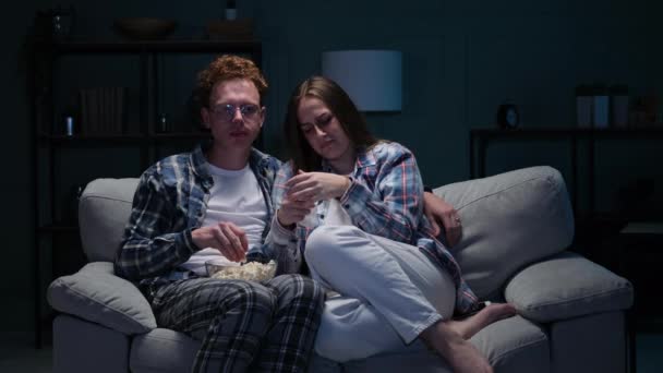 Καυκάσιο ζευγάρι βλέπει ταινία μαζί στο σαλόνι στο σπίτι — Αρχείο Βίντεο