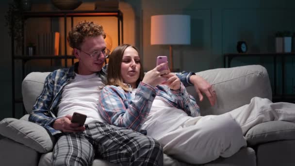 Jeune couple heureux s'amuser en utilisant un smartphone à la maison — Video