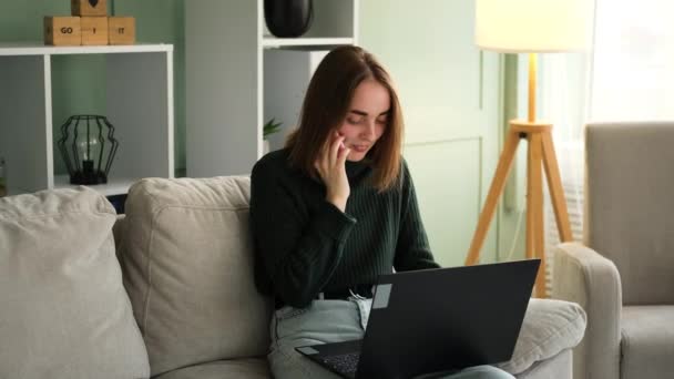 自宅で仕事をし、コンピュータを入力しながら電話で話す女性 — ストック動画
