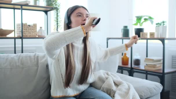自宅でヘッドフォンで音楽を楽しむ女性 — ストック動画