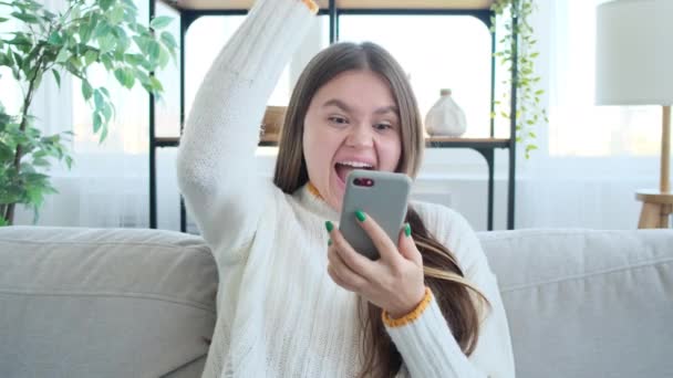 Mulher feliz desfrutar de sucesso no telefone móvel em casa — Vídeo de Stock