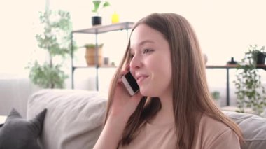 Esmer kadın telefonla konuşuyor ve gülüyor.