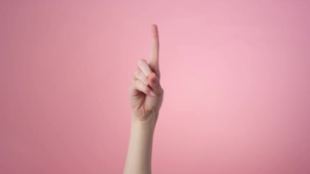 Close-up of a shaking finger on a pink background — Stock Video