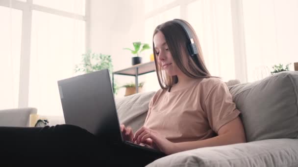 幸せな女性リスニング音楽と作業ノートパソコンで自宅 — ストック動画