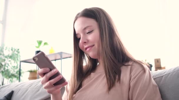 若い笑顔の女性が携帯電話を使って — ストック動画