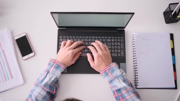 Vista superior de las manos escribiendo en el ordenador portátil en el lugar de trabajo — Vídeos de Stock