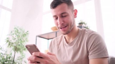 Evinde telefonuyla dinlenen bir adamın yakın çekimi.