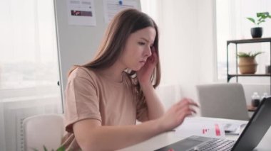 Baş ağrısı olan ofis çalışanı şakaklarına dokunuyor.