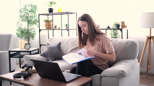 Mujer satisfecha trabajando sentada en un sofá — Vídeo de stock