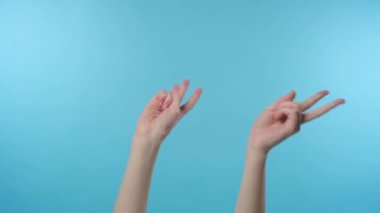 Kadın elleri farklı hareketler yapıyor ve dans ediyor.