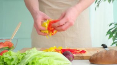 Adam tabağa doğranmış biber koyar.