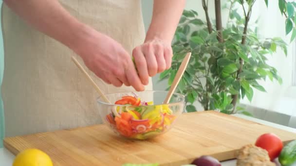 L'homme remplit le bol de feuilles fraîches dans une cuisine — Video