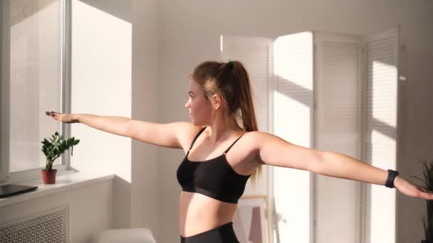 Молодая женщина практикует йогу в помещении — стоковое видео