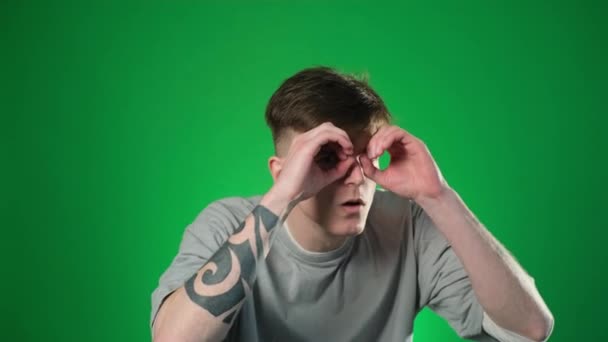 Surprised Man Gray Shirt Looking Fingers Eyes Making Binoculars Gesture — Stock Video