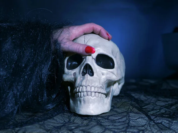 邪悪な魔女手上の頭蓋骨上の暗い背景 — ストック写真