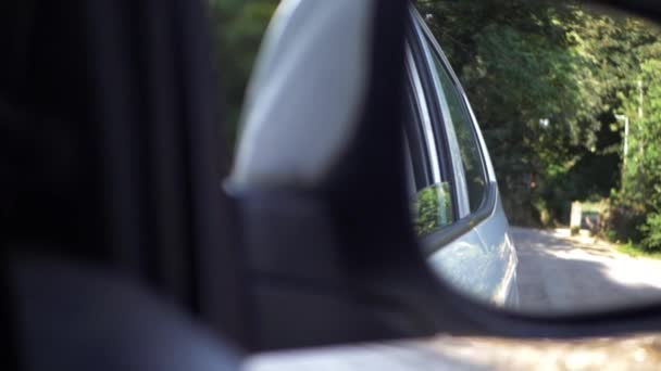 Pohled na venkovskou silnici přes zrcátko auta — Stock video