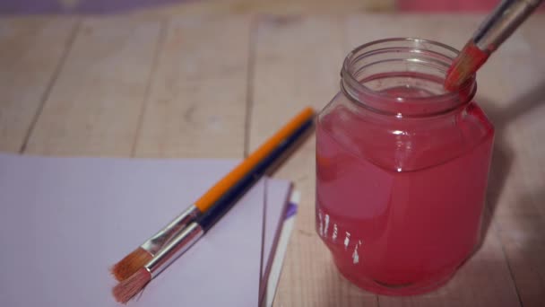 Artista lavando pincel de pintura en frasco de agua — Vídeo de stock