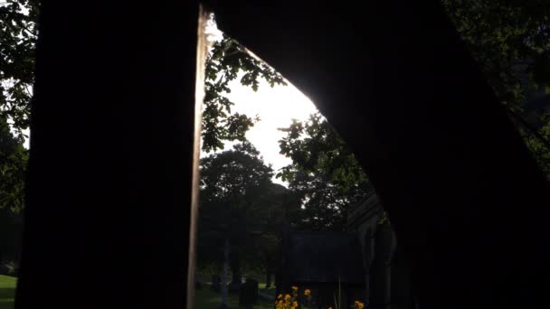 Soleil brille à travers la cour de l'église lych gate — Video