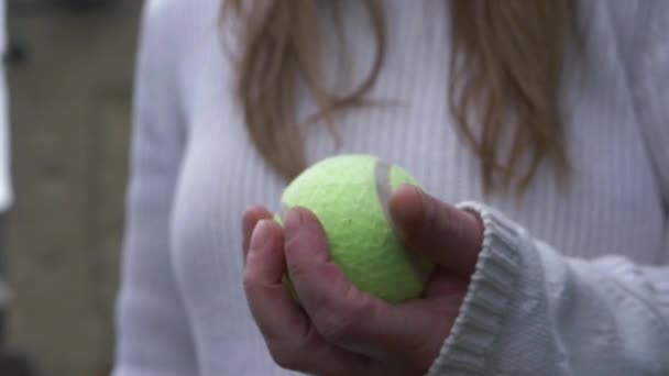 Kobieta rzuca piłkę tenisową w powietrze i łapanie — Wideo stockowe