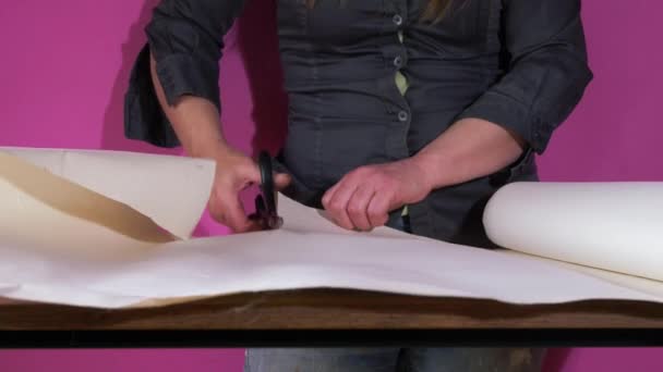 Cutting wallpaper on a table with scissors — Stock Video