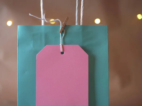 Cadeauzakje met tags op bokeh achtergrond medium schot — Stockfoto