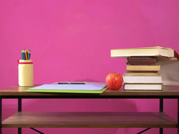 Ders masasında kalemli ve klasörlü kitaplar.