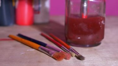 Sanat ve zanaat fırçaları ve temizlik için bir kavanoz su.
