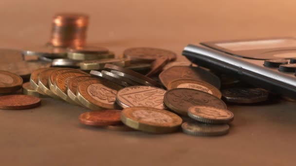 Geld munten en rekenmachine op een bureau — Stockvideo