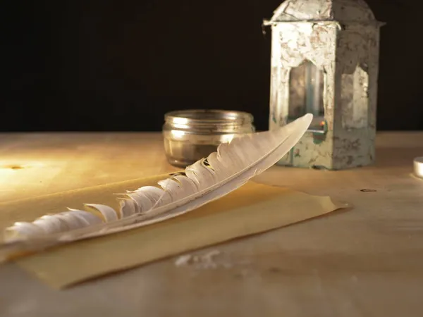 Quill e inchiostro su scrivania in legno con vecchia lanterna — Foto Stock
