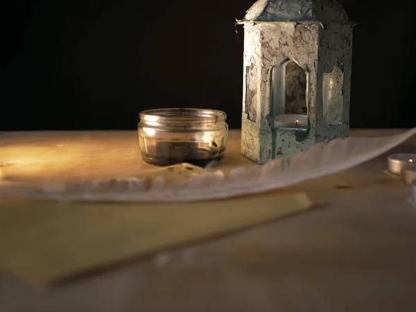 Quill e inchiostro su scrivania in legno con vecchia lanterna — Foto Stock