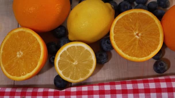 Apelsiner citroner och blåbär för C-vitamin på färgglada bakgrund — Stockvideo