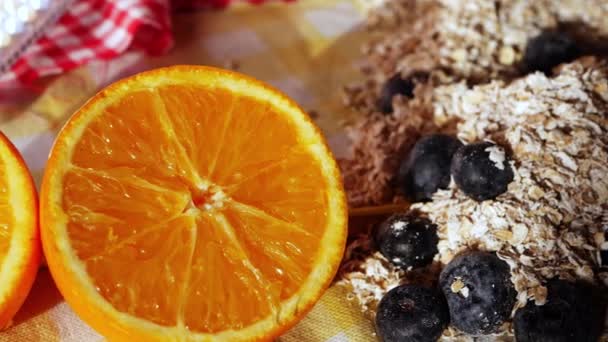 Свежие апельсины с овсянкой и черникой на завтрак — стоковое видео
