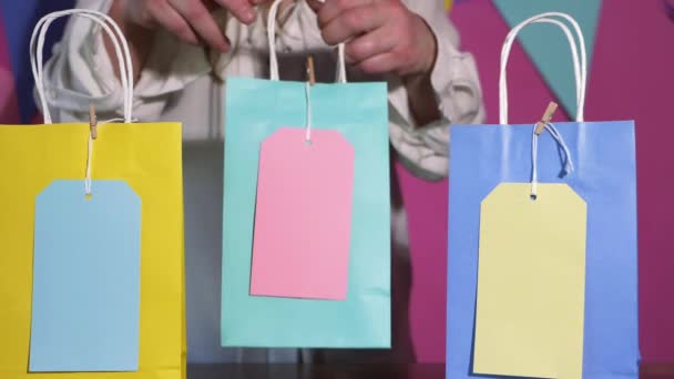 Verjaardag meisje neemt cadeau tassen in kleurrijke achtergrond — Stockvideo