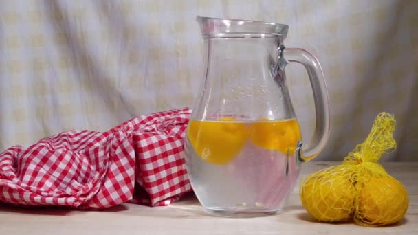 Limones frescos en rodajas en jarra de agua — Vídeo de stock