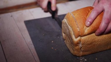 Bir somun taze ekmek dilimliyorum.