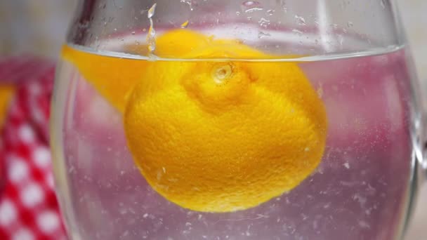 Νωπά λεμόνια επιπλέουν σε μια κανάτα νερό — Αρχείο Βίντεο
