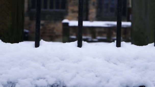 Zábradlí pokryté sněhem s kostelem budovy v pozadí — Stock video