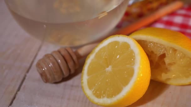 Lemon dengan sendok madu pada latar belakang kayu — Stok Video