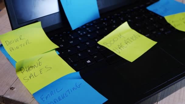 Laptop of stressed employee covered with sticky note reminders on a desk — Stock Video