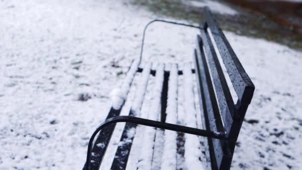Empty park bench covered after snowfall — Stock Video