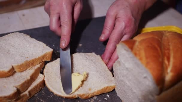 Mantequilla de una rebanada de pan blanco recién rebanado — Vídeos de Stock