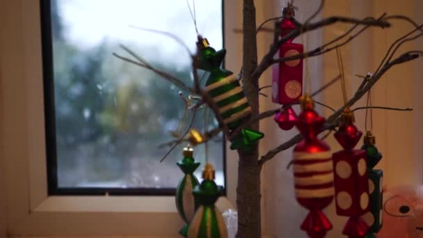 Kerst decoraties op een boom als sneeuw valt buiten — Stockvideo