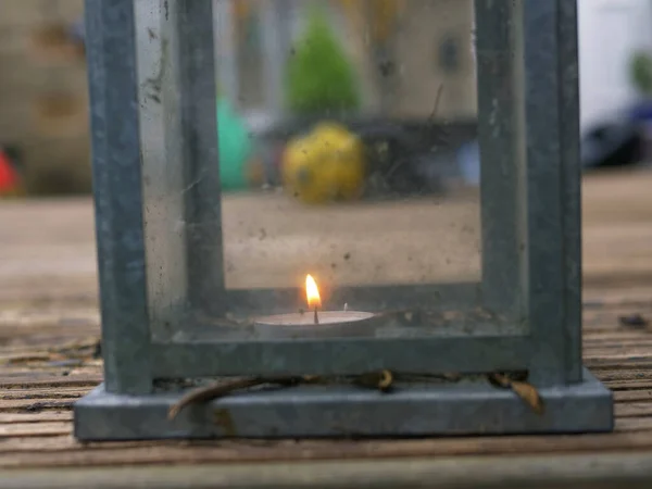 Staubige alte Glaslaterne mit Kerze brennt auf Gartenterrasse — Stockfoto