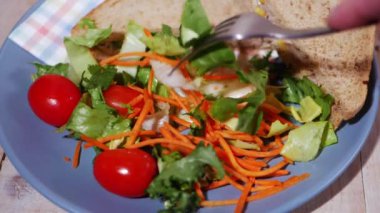Öğle yemeğinde taze salata ve sandviç yiyorum.