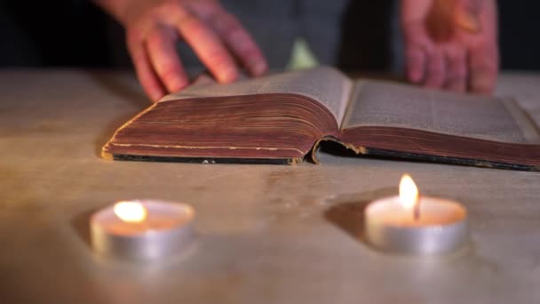 Читання старої книги свічками — стокове відео