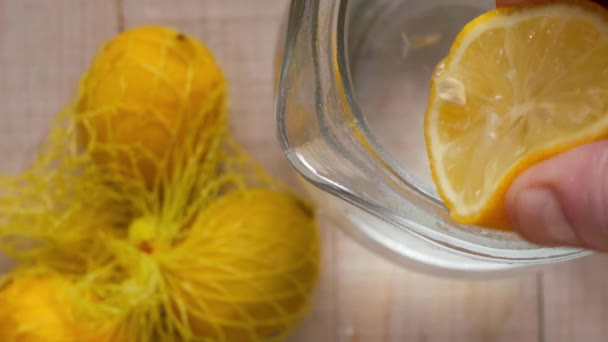 Stlačování čerstvé citrónové šťávy do džbánu s vodou — Stock video