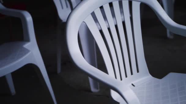 Rows of empty white plastic chairs at an event — Stock Video