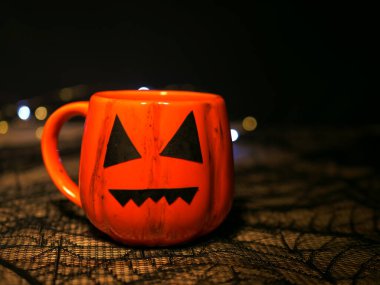 Koyu arkaplanda Cadılar Bayramı süslemesi kabağı kupası 