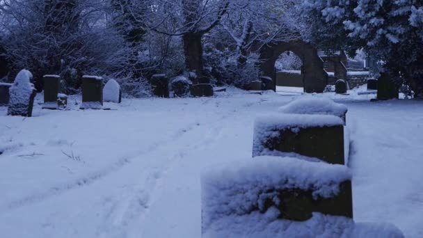 Patio de la iglesia en el oscuro día de invierno con nieve cayendo — Vídeos de Stock